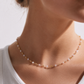 Lenet Necklace pearl and gold beaded necklace worn on model with delicate layered jewelry styling.