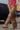 Person wearing leopard print pants and a pink top in an urban setting