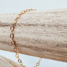 Levvet gold-plated chain bracelet laid out on a wooden surface by Matte Jewelry