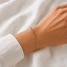 Lina Bracelet delicate gold chain bracelet worn on wrist with polished gold finish and minimalist design.