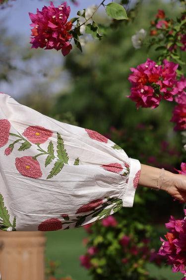 Close up of white mini dress with pink floral print long sleeve