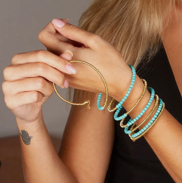 Model wearing Lolita 6 Loops Bracelet by Matte, gold wire with turquoise gemstone beads
