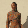 Lumina Blouse by Matte – green floral blouse with smocked cuffs and vibrant print, close-up view