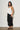Side view of the Lumit black balloon pants styled with a sleeveless top, showcasing the relaxed balloon silhouette.