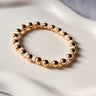 Lunaire gold stretch bracelet with white beads by MatteGold  on a white surface