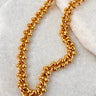 Gold chain anklet on a marble surface