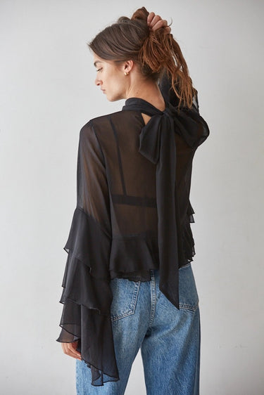 Back view of the Maruk Blouse highlighting its lightweight sheer fabric, flowing silhouette, dramatic bell sleeves, and elegant drape.