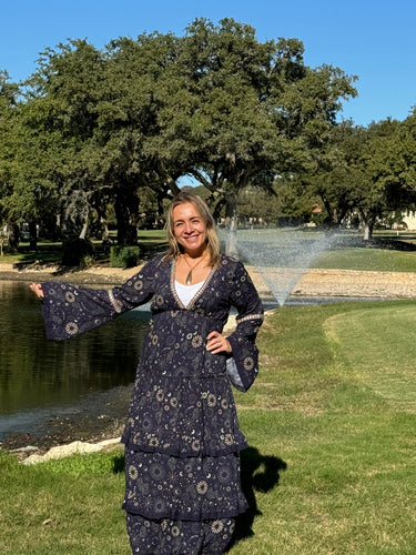 Model wearing Meli Maxi Dress in navy with metallic star print and long sleeves.