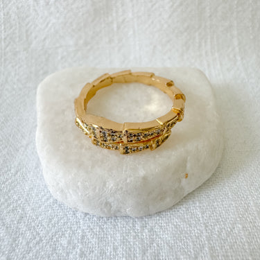 Gold-plated pavé snake-inspired ring with crystal detailing on marble surface – Merida Ring by Matte.