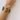 Minutti Bracelet featuring glossy olive green round beads and slim gold-tone bars in a sculptural multi-row design worn on a woman’s wrist.