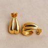 Gold mini hoop earrings on white linen backdrop, sculptural shape, Moltem Hoop Earrings.
