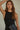 Model wearing the black Montauk Top with a ribbed knit texture, sleeveless fitted silhouette, cropped length, and elegant satin skirt for a modern everyday look.