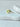 Montego Ring gold band with green crystal stone on white stone surface
