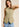 Front view of the Muse Vest in soft sage green highlighting the clean tailored construction, fitted silhouette, and sleeveless design.