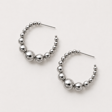 Naples Hoop Earrings featuring polished silver-plated hoop earrings with graduated sphere bead detailing, a rounded hoop silhouette, mirror finish, secure post-back closure, lightweight design, and modern statement style.