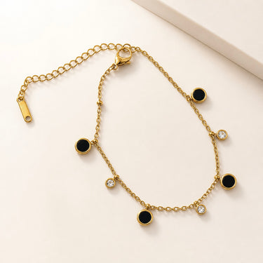 Nau Bracelet featuring a fine gold chain with black enamel charms and crystal accents on a white background.