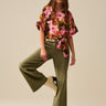 Nerina Pant – olive green wide-leg stretch pants worn styled with printed top, full-length front view.
