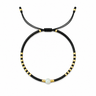 Nodath Bracelet black adjustable beaded bracelet with gold accents and ivory stone centerpiece on white background.