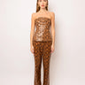 Editorial shot of the Nomi Bandeau Top in metallic bronze snake print, styled with gold jewelry and matching pants, Matte fashion.