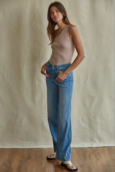 Ojai Top side view showcasing the fitted ribbed fabric, asymmetrical neckline, and cropped fit with high-waisted denim.