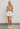 Model wearing white frayed short with drawstring waist and sneakers — casual summer look.
