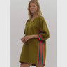 Model wearing olive Krewer Dress with colorful side stripes and textured fabric.