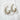 Pair of silver-plated Oudenaarde Hoop Earrings with bubble texture displayed on a white marble slab.