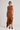Woman wearing the Pauletti knit midi dress with a fitted silhouette and asymmetric ruffled hem, front view.