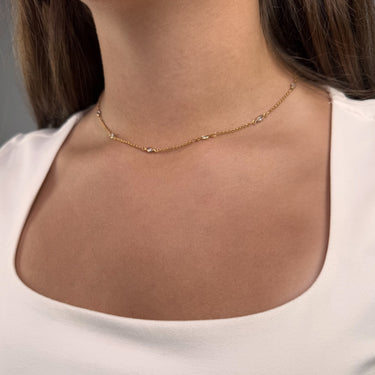 Model wearing Piper necklace by Matte, gold filled minimalist chain layered with other necklaces