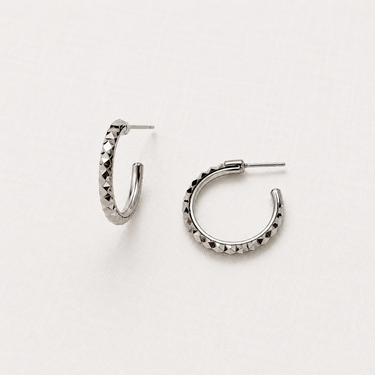 Pisa Hoop Earrings featuring polished silver-plated hoop earrings with a faceted diamond-cut texture, slim rounded silhouette, mirror finish, secure hinged closure, lightweight design, and elegant everyday style.