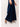 Navy blue wide-leg pants with crystal embellished denim detail close-up worn by a person on a light gray background
