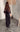 Woman wearing sheer black Ammica Maxi Dress with beaded details indoors under soft light.