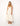 "Woman wearing an ivory midi dress with gold star embroidery, sleeveless V-neck, tiered skirt, styled with tan sandals – summer resort fashion"