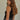 Regi Top side view of black sleeveless ribbed tank top with close fit silhouette.