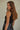 Regi Top side view of black sleeveless ribbed tank top with close fit silhouette.