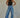 Regi Top black fitted sleeveless top paired with relaxed blue denim jeans.
