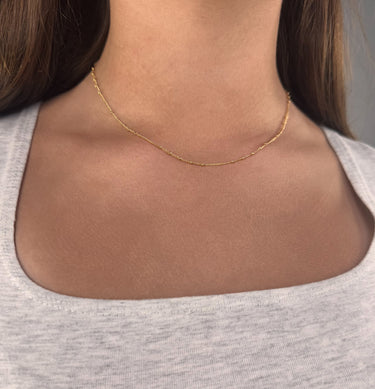 Model wearing Remote Gold necklace by Matte, delicate gold plated beaded chain