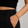 Remu Bracelet black beaded adjustable bracelet with gold accents worn on wrist with black outfit.
