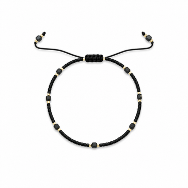 Remu Bracelet adjustable black beaded bracelet with gold-tone details and center stone on white background.