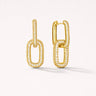 Risha Huggie Earrings in gold featuring elongated interlocking links with pavé cubic zirconia detailing, displayed on a soft light gray background with subtle shadow, modern lightweight drop earrings