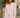 woman wearing Rosewood Ruffle Blouse in light pink, long sleeves, button-down with ruffle trim, styled with blue jeans on the street