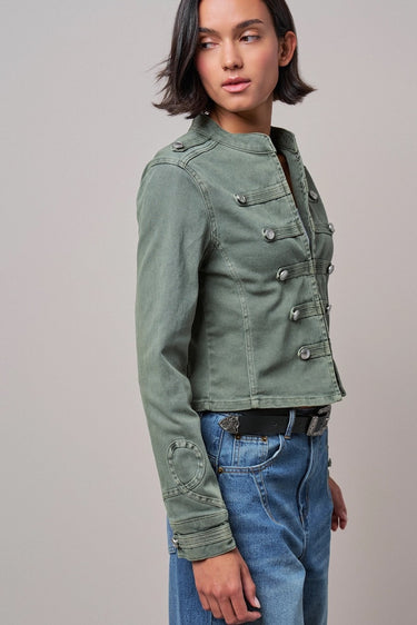 Front view of woman wearing the Sacha washed sage cropped military jacket with blue jeans.