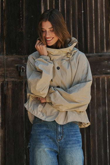 Front view of the Sakany lightweight beige jacket showing the oversized pockets, hood, and comfortable fit.