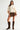 Full outfit featuring the Sienu Sweater in cream styled with a brown mini skirt and knee-high boots for an effortless everyday look.