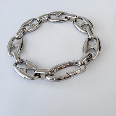 Silver oval link bracelet with polished finish and cubic zirconia accents on clasp link