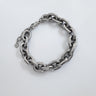 Silver chunky chain bracelet with polished oval links and small heart charm on clasp, displayed on white background