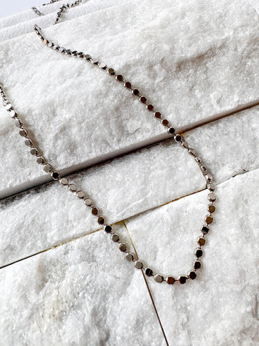 Stage Necklace by Matte, silver coin chain necklace on white textured background