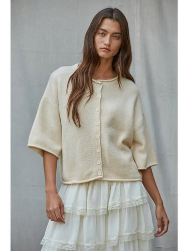 Talina lightweight ivory knit cardigan with a relaxed fit, elbow-length sleeves, button-front closure, and rolled-edge finish, shown from the front.