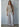 Talina lightweight knit cardigan featuring a button-front design, relaxed fit, and rolled-edge detailing, styled over a matching neutral outfit.