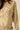 Close-up of embroidered tiger design on beige knit sweater.